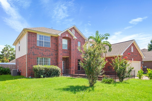 view of front of property featuring central air condition unit, a front yard, an attached garage, fence, and brick siding