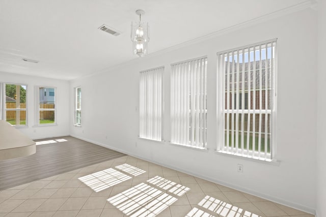 spare room with visible vents, crown molding, tile patterned flooring, and baseboards