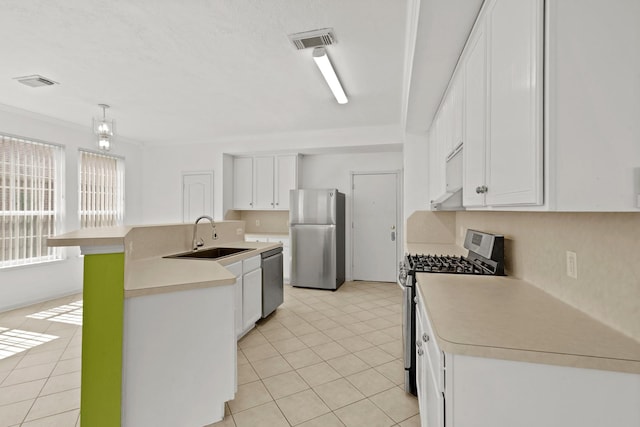 kitchen with appliances with stainless steel finishes, light countertops, a sink, white cabinetry, and visible vents