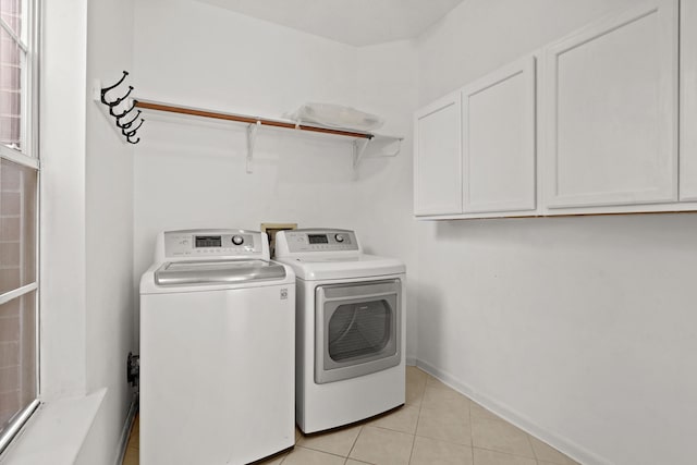 washroom featuring light tile patterned flooring, independent washer and dryer, cabinet space, and baseboards