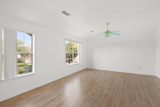 spare room featuring a ceiling fan, visible vents, baseboards, and light wood-type flooring