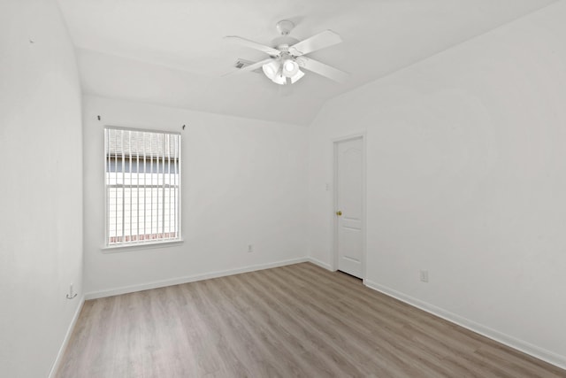 unfurnished room featuring light wood-type flooring, a ceiling fan, visible vents, baseboards, and lofted ceiling