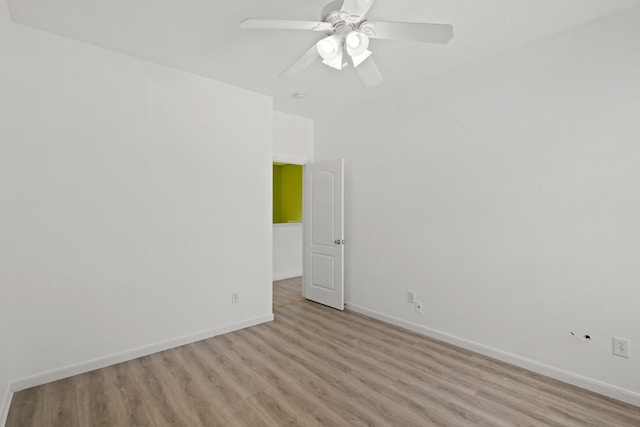 empty room with baseboards, a ceiling fan, and light wood-style floors