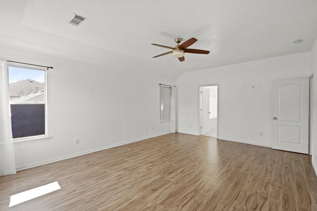 empty room featuring visible vents, light wood-type flooring, a ceiling fan, and baseboards