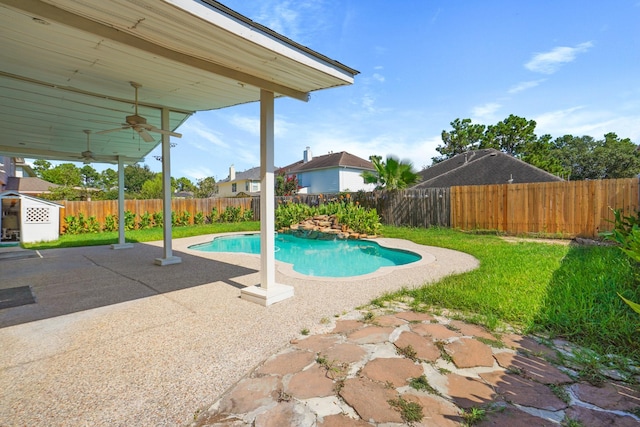 view of pool with a fenced backyard, a fenced in pool, a patio, a ceiling fan, and a lawn