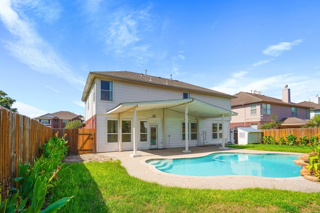rear view of house with an outbuilding, a storage shed, a ceiling fan, and a fenced backyard