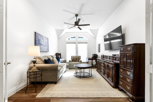 living room featuring baseboards, wood finished floors, ceiling fan, and vaulted ceiling