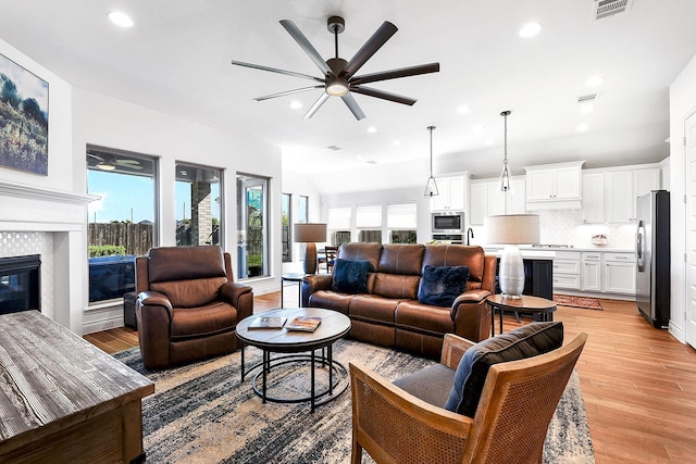 living room with visible vents, a ceiling fan, light wood finished floors, and recessed lighting