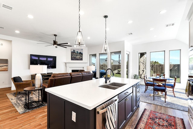 kitchen featuring visible vents, ceiling fan, light wood-style flooring, and a sink
