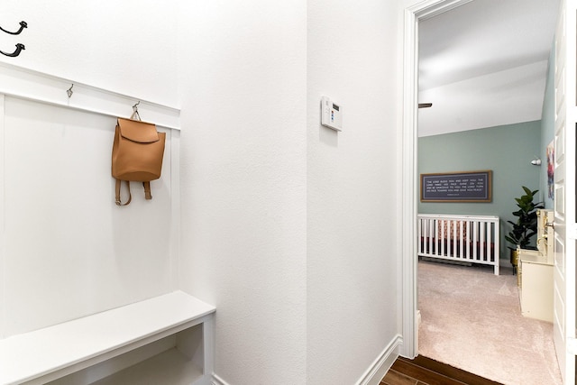 mudroom featuring dark wood-type flooring and baseboards