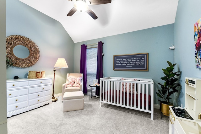 bedroom with carpet flooring, a ceiling fan, vaulted ceiling, baseboards, and a crib