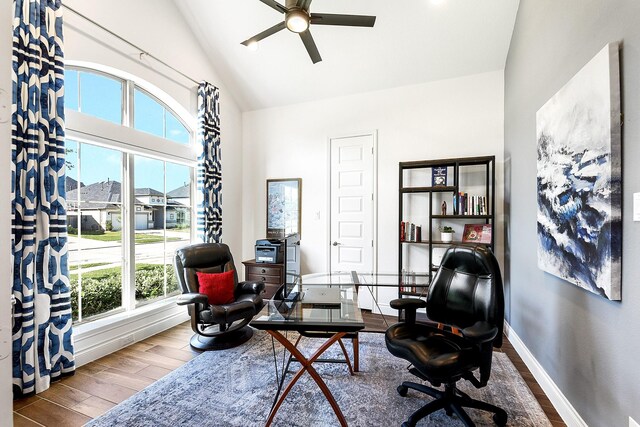 sitting room featuring baseboards, high vaulted ceiling, wood finished floors, and a ceiling fan