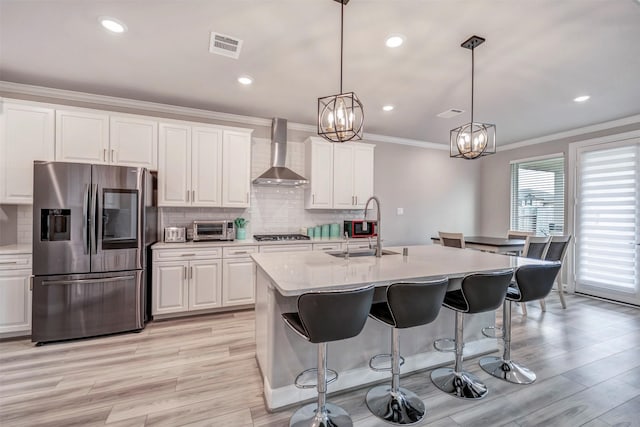 21443 Petherton Dr, Tomball, TX 77375 - kitchen featuring visible vents, a toaster, wall chimney range hood, a sink, and stainless steel appliances
