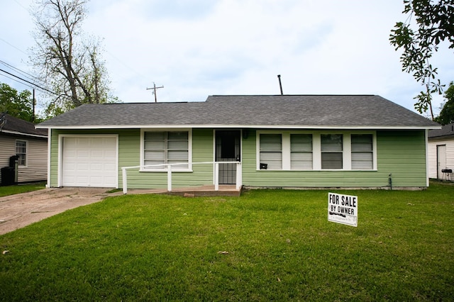 ranch-style home with a shingled roof, a front lawn, and driveway
