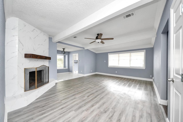 13003 Foxburo Dr, Houston, TX 77065 - unfurnished living room with visible vents, baseboards, beam ceiling, and a fireplace