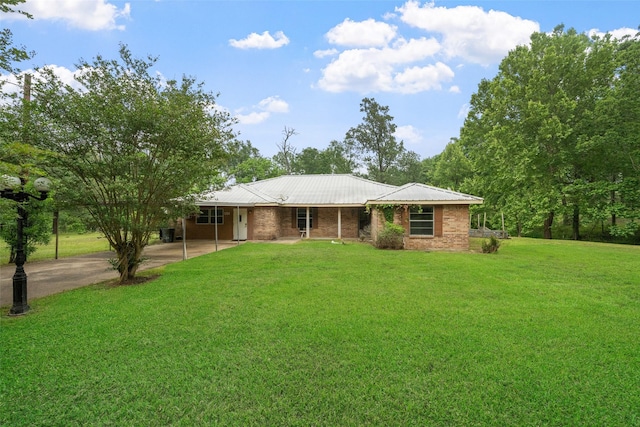 ranch-style house with driveway, a carport, metal roof, and a front yard