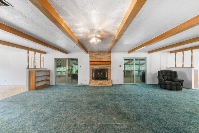 unfurnished living room featuring carpet flooring, beamed ceiling, visible vents, ceiling fan, and a brick fireplace