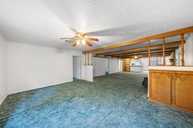 unfurnished living room featuring visible vents, a ceiling fan, a textured ceiling, and carpet flooring