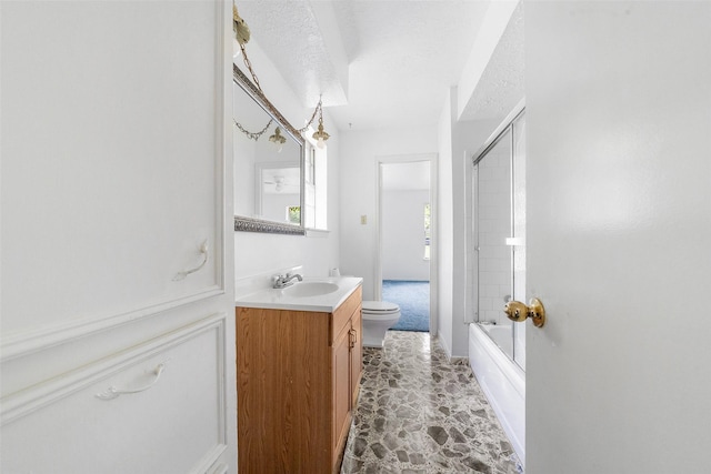 bathroom with bath / shower combo with glass door, vanity, and toilet