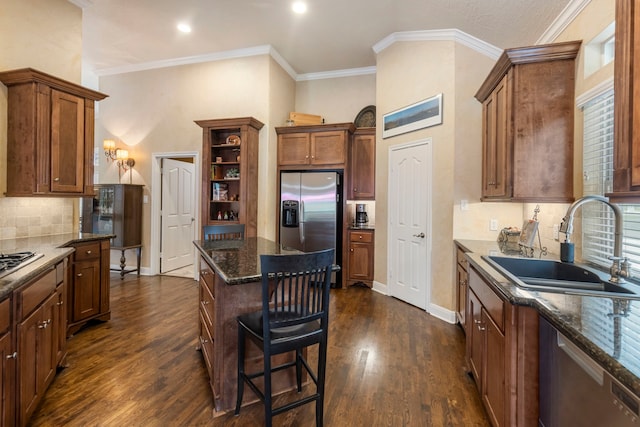 kitchen featuring dark wood-style flooring, a sink, dark stone countertops, stainless steel appliances, and decorative backsplash