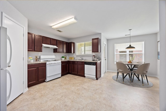 kitchen featuring white appliances, under cabinet range hood, a sink, visible vents, and pendant lighting