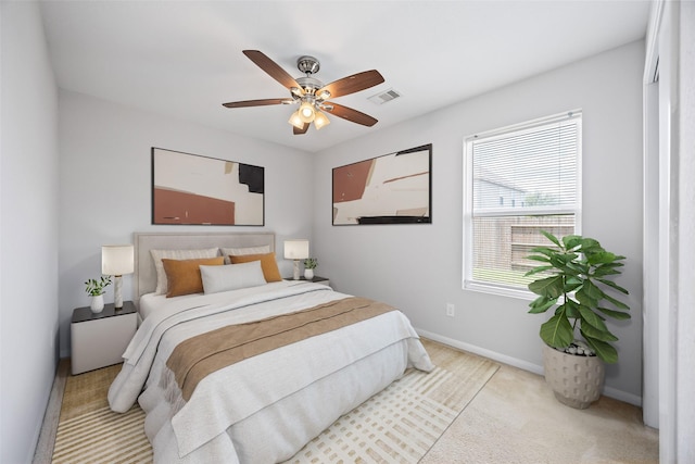 carpeted bedroom featuring baseboards, visible vents, and a ceiling fan