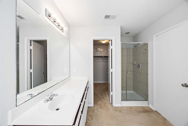 full bath featuring a walk in closet, visible vents, a shower stall, and vanity