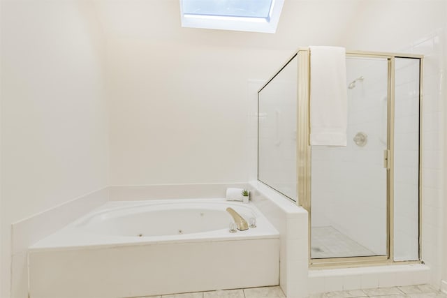 full bath with a whirlpool tub, a skylight, a shower stall, and tile patterned flooring