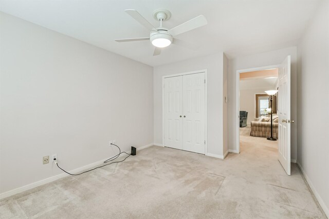 unfurnished bedroom with carpet floors, baseboards, ceiling fan, and a closet