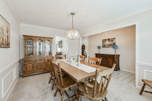 dining room featuring an inviting chandelier, ornamental molding, and light colored carpet