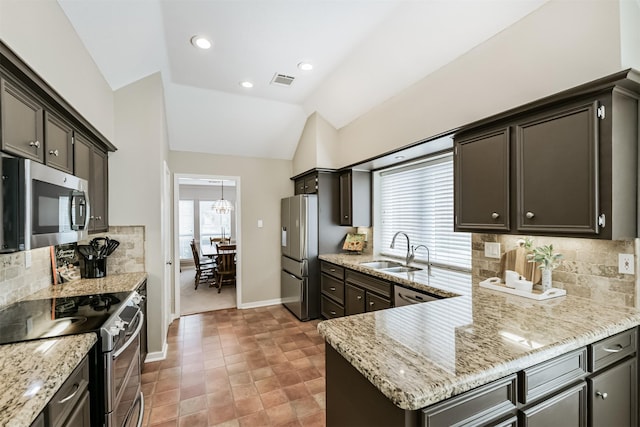 kitchen with visible vents, vaulted ceiling, a sink, baseboards, and stainless steel appliances