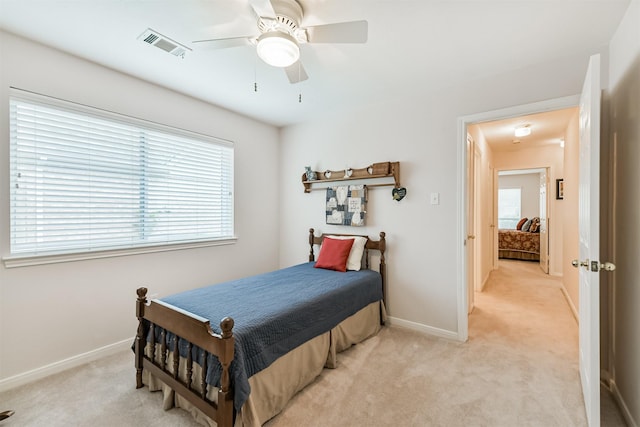 bedroom featuring baseboards, light carpet, a ceiling fan, and visible vents
