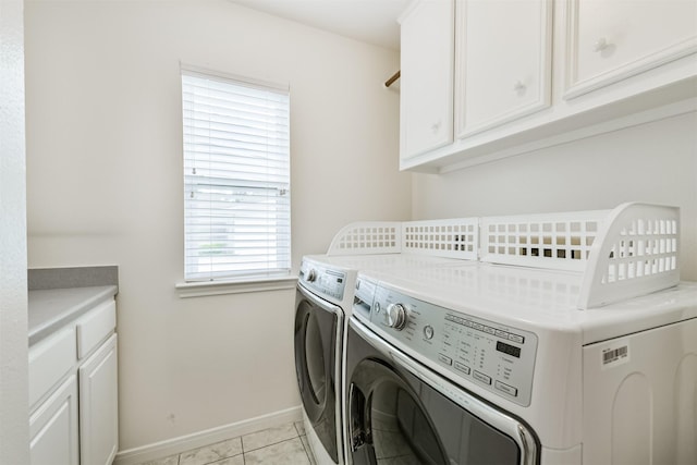 laundry area with baseboards, cabinet space, light tile patterned flooring, and independent washer and dryer