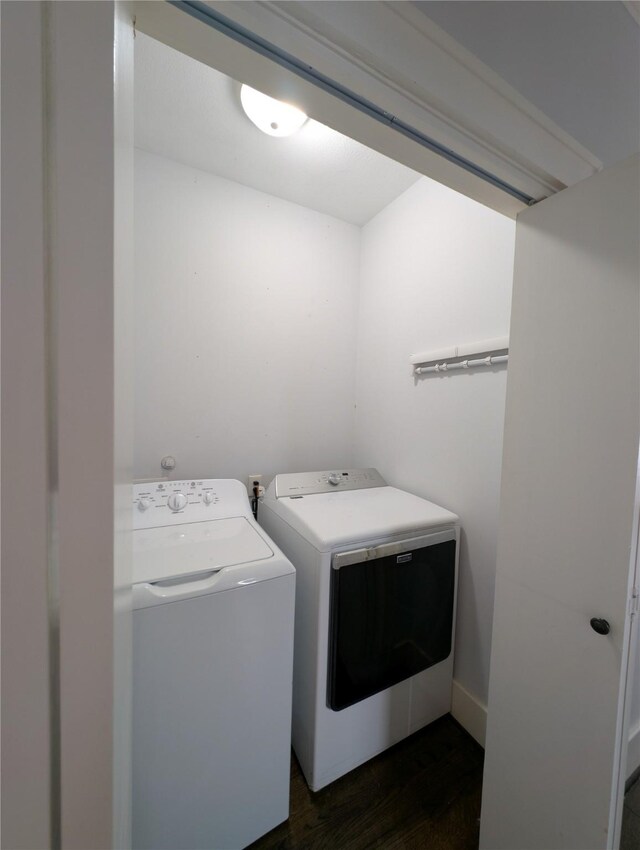 clothes washing area with laundry area, dark wood-type flooring, and washer and clothes dryer