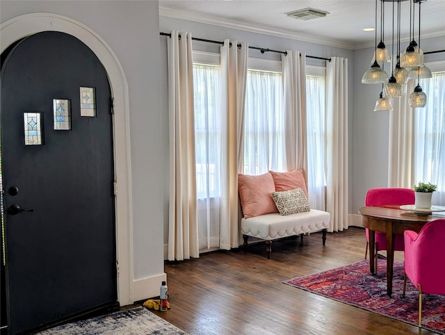 entryway featuring visible vents, arched walkways, crown molding, and wood finished floors