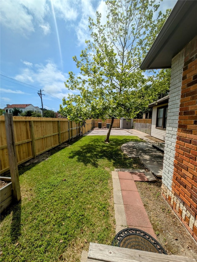 view of yard with an outdoor structure, a fenced backyard, and a patio area