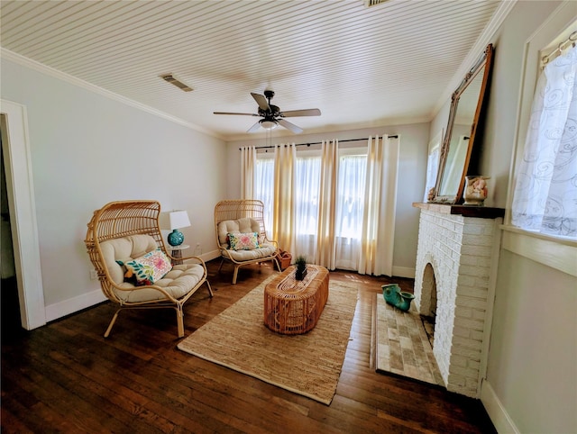 living area featuring baseboards, ornamental molding, wood-type flooring, and a ceiling fan