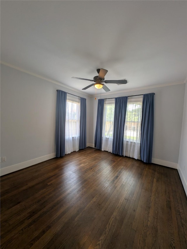 empty room with crown molding, a ceiling fan, dark wood-style flooring, and baseboards