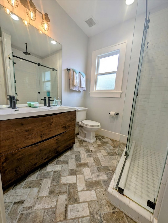 bathroom with vanity, baseboards, a shower stall, and visible vents