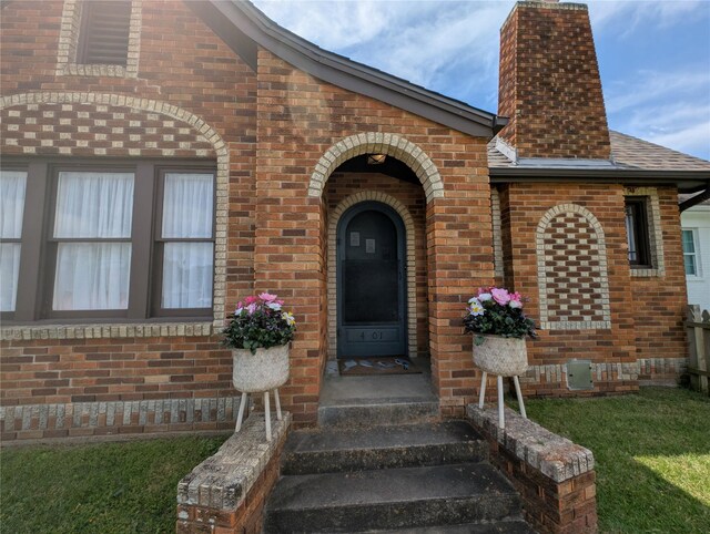 4701 Woodrow Ave, Galveston, TX 77551 - entrance to property featuring brick siding, a chimney, and roof with shingles