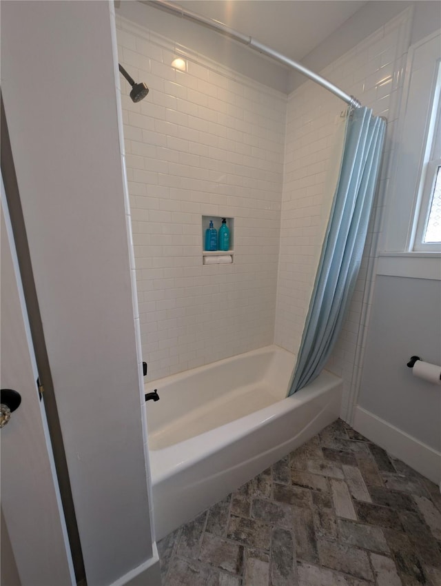 bathroom featuring baseboards and shower / tub combo
