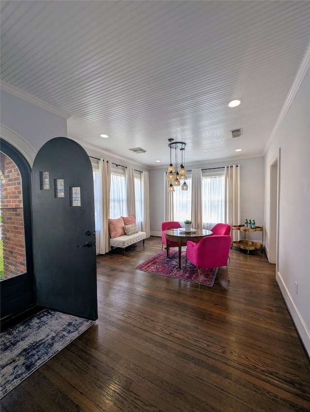 dining space featuring crown molding, arched walkways, wood finished floors, and visible vents
