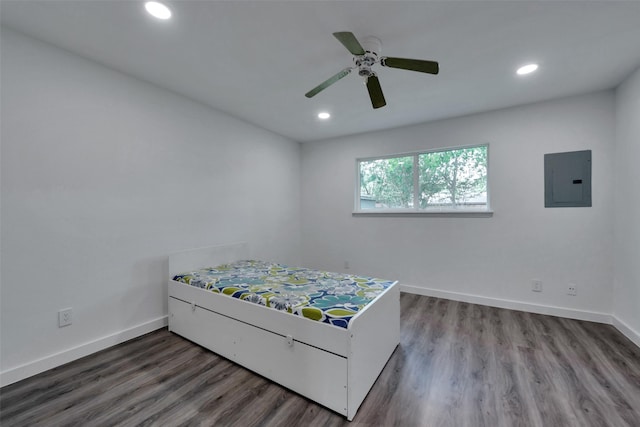 bedroom with baseboards, electric panel, recessed lighting, and wood finished floors