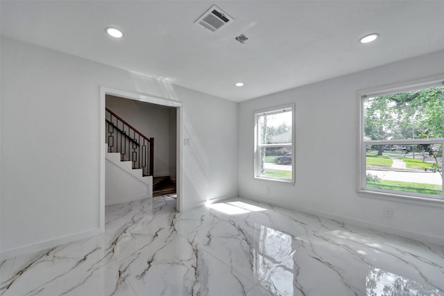 empty room with visible vents, recessed lighting, baseboards, and stairway