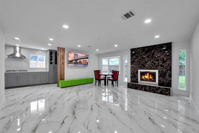 living room with visible vents, recessed lighting, and a high end fireplace