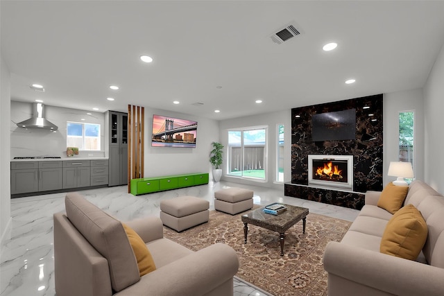 living room featuring visible vents, recessed lighting, marble finish floor, and a high end fireplace