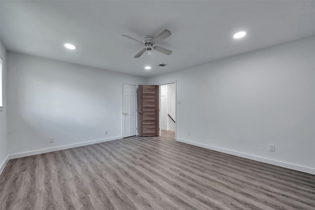 empty room featuring baseboards, ceiling fan, and wood finished floors
