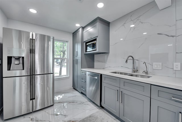 kitchen featuring appliances with stainless steel finishes, a sink, marble finish floor, recessed lighting, and gray cabinetry