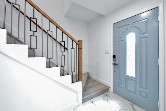 foyer featuring stairs, baseboards, and marble finish floor