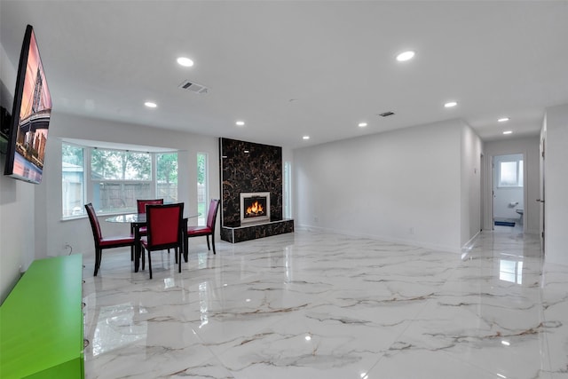 dining room featuring a premium fireplace, visible vents, recessed lighting, and a wealth of natural light